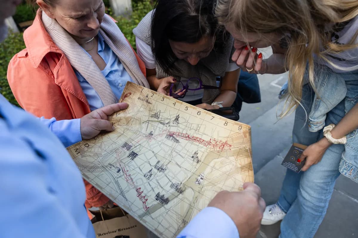 Uczestnicy integracji firmowej nad mapą z zagadkami