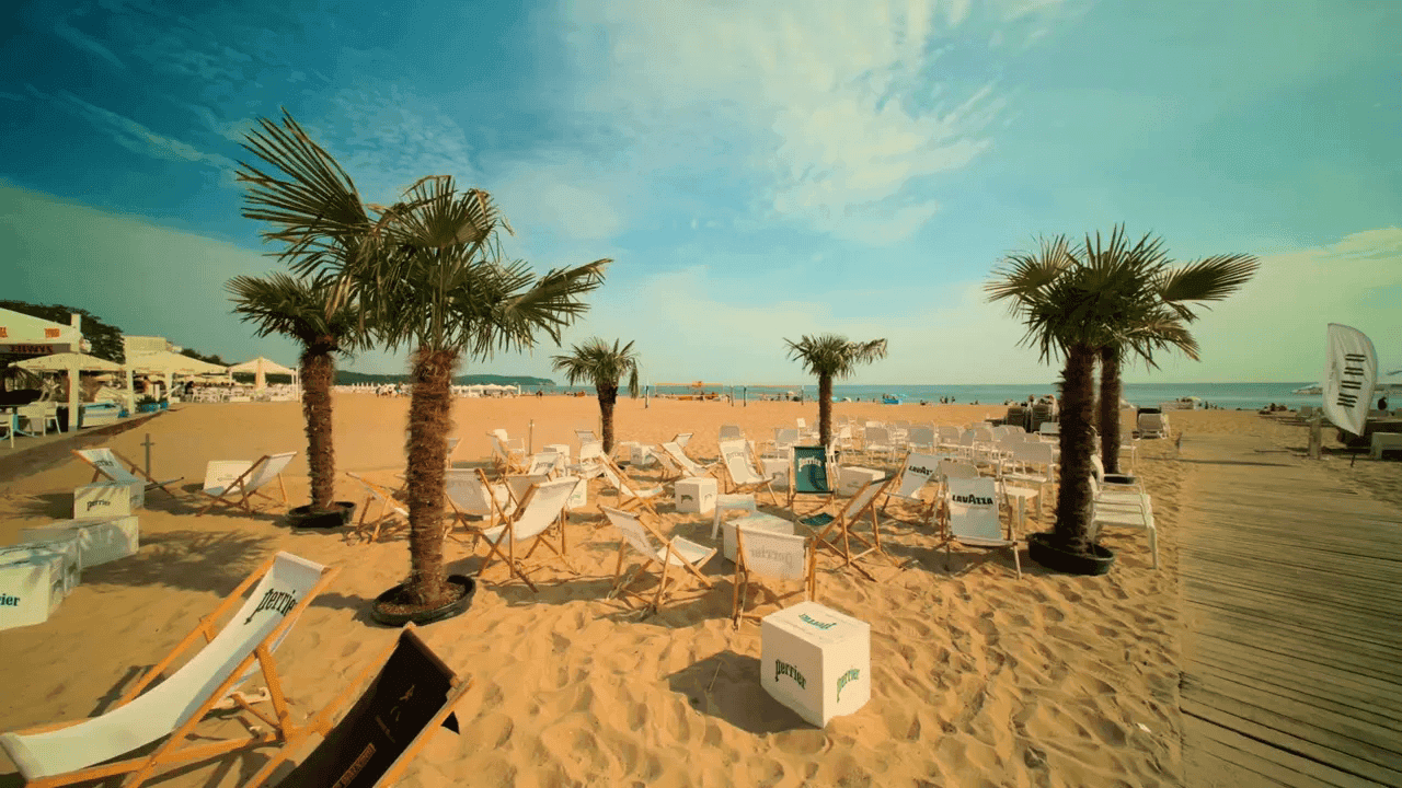 Beach bar na plaży z leżakami i palmami - integracja firmowa na zewnątrz